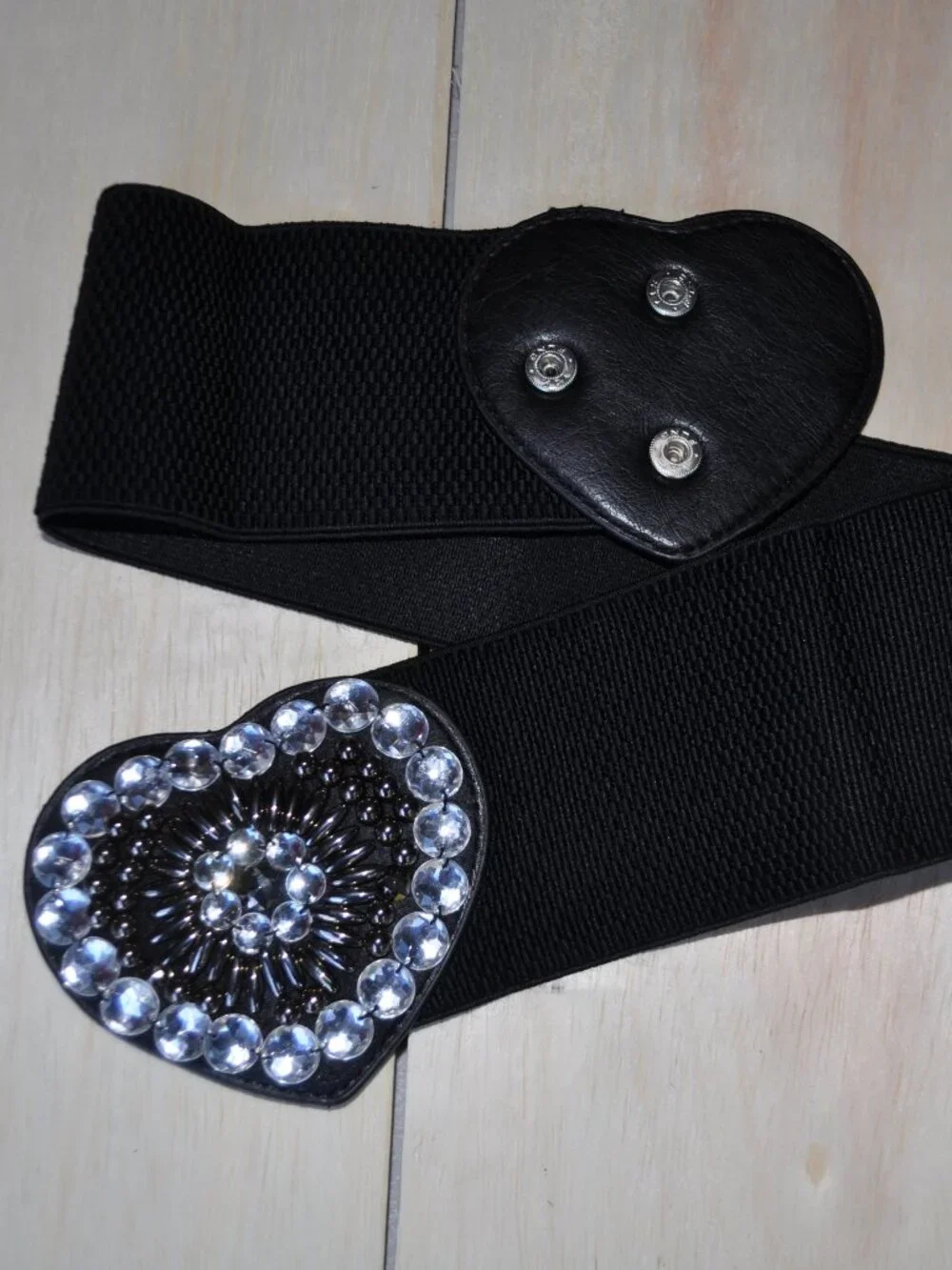 women's black elastic waistband belt features a distinct faux leather heart-shap